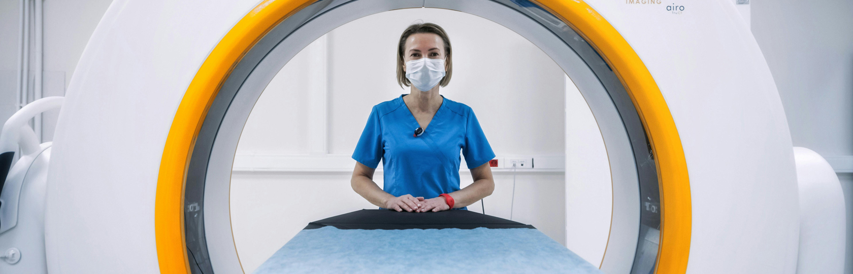 a medical tech looking through an MRI scanner machine